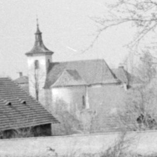 Rural landscape with bare trees, old church, and dirt road.