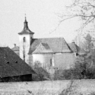 Rural scene with bare trees, old church, and roadside.
