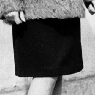 Young woman wearing 1960s-style coat and skirt.