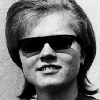 Young person wearing sunglasses and polo shirt.