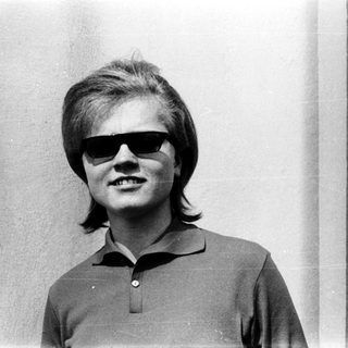Young person wearing sunglasses and polo shirt.