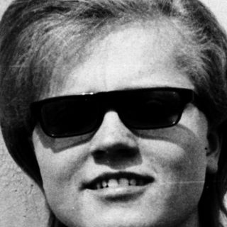 Young person wearing sunglasses and polo shirt.