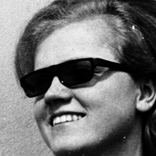 Smiling person wearing sunglasses and polo shirt.