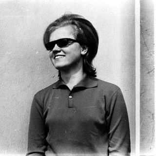 Smiling person wearing sunglasses and polo shirt.