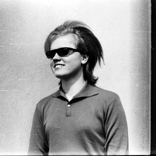 Young person wearing sunglasses and short hair.