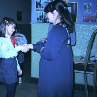 School ceremony with students shaking hands.