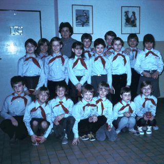 Scout group posing indoors with leader.