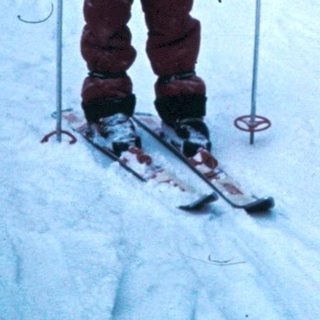 Two children skiing on snow-covered slope.