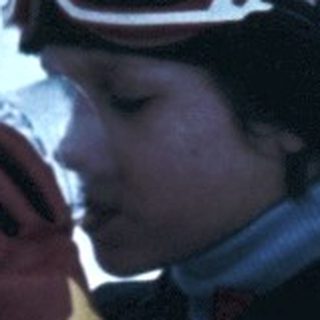 Person skiing in snow, taking a drink.