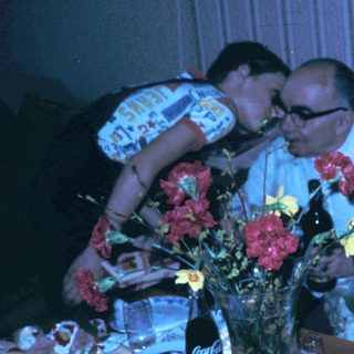 Family celebrating birthday indoors with cake and gifts.