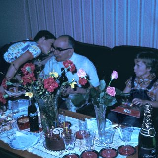 Family celebrating birthday indoors with cake and gifts.