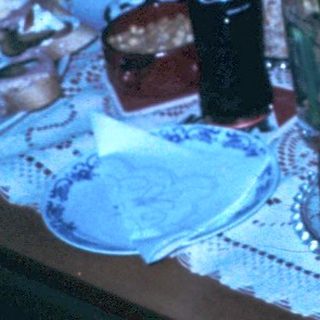 Family celebrating birthday indoors with cake and gifts.