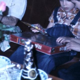 Family gathering reading books indoors.