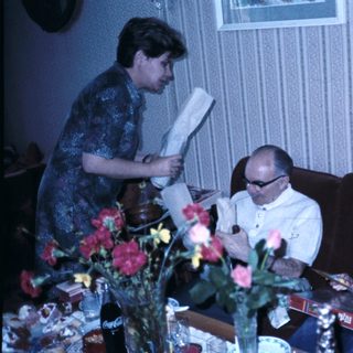 Family gathering reading books indoors.