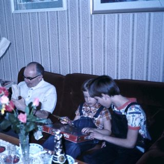 Family gathering reading books indoors.