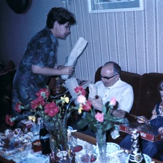 Family gathering reading books indoors.