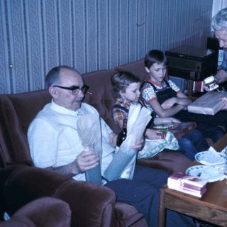 Family gathering with cake and reading materials.