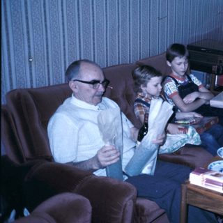 Family gathering with cake and reading materials.