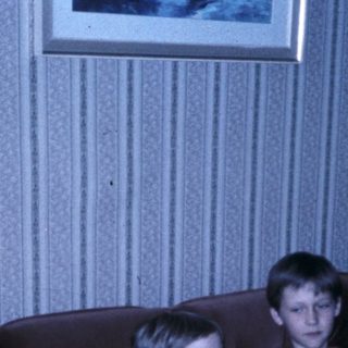 Family celebrating a birthday indoors with cake and gifts.
