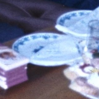 Family celebrating a birthday indoors with cake and gifts.