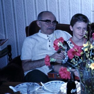 Family gathering with flowers on dining table.