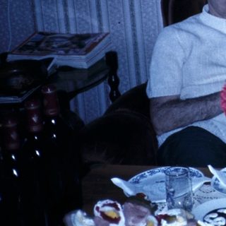 Family gathering with flowers on dining table.