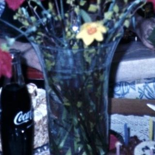 Family gathering with flowers on dining table.