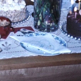 Family celebrating birthday with cake and drinks.
