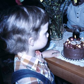 Child blowing out birthday cake candles.