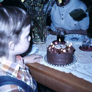 Child blowing out birthday cake candles.