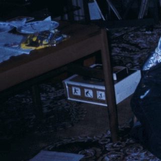 Three people assembling a puzzle on the floor.