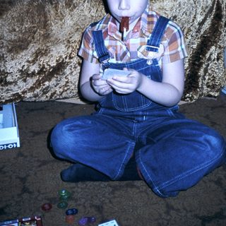 Boy playing with small handheld device.