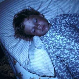 A person sleeping peacefully in bed.