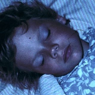 A person sleeping peacefully in bed.