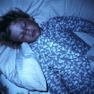 A person sleeping peacefully in bed.