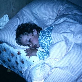 A person sleeping peacefully in bed at night.