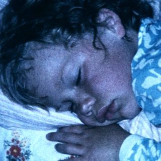 A person sleeping peacefully in bed at night.