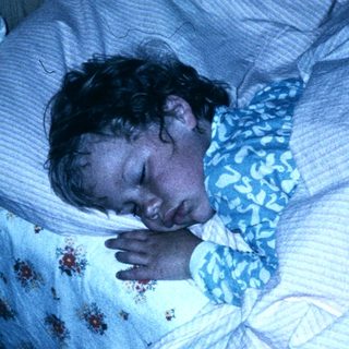A person sleeping peacefully in bed at night.
