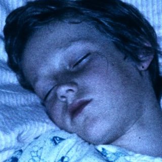 A person sleeping peacefully in a hospital bed.