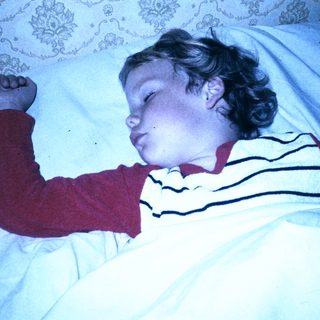 Child peacefully sleeping in striped pajamas.