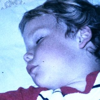 Child peacefully sleeping in striped pajamas.