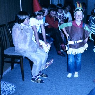Children dressed in costumes playing indoors.