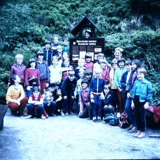 Group hiking with backpacks at mountain trailhead.