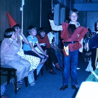 Children dressed in costumes performing on stage.