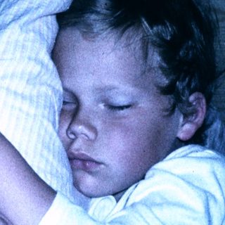 Child peacefully sleeping in bed at night.