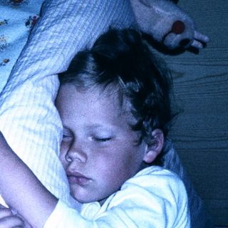 Child peacefully sleeping in bed at night.