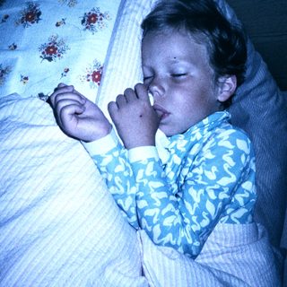 Child peacefully sleeping in blue floral pajamas.