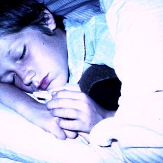 A child sleeping peacefully with a stuffed toy.