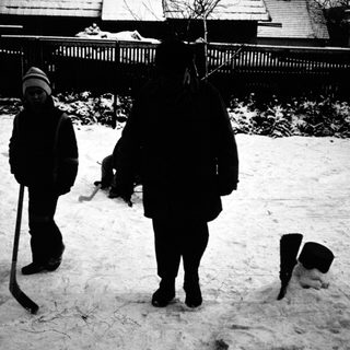 Two people shoveling snow in backyard.