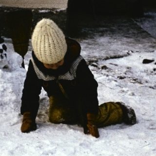Two children playing in deep snow.